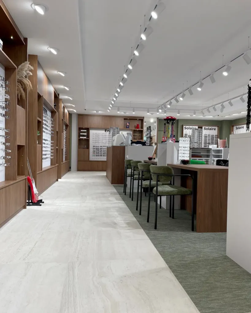 Mobilier sur mesure boutique d’optique – concept chaleureux en bois et Bolon vert Sage